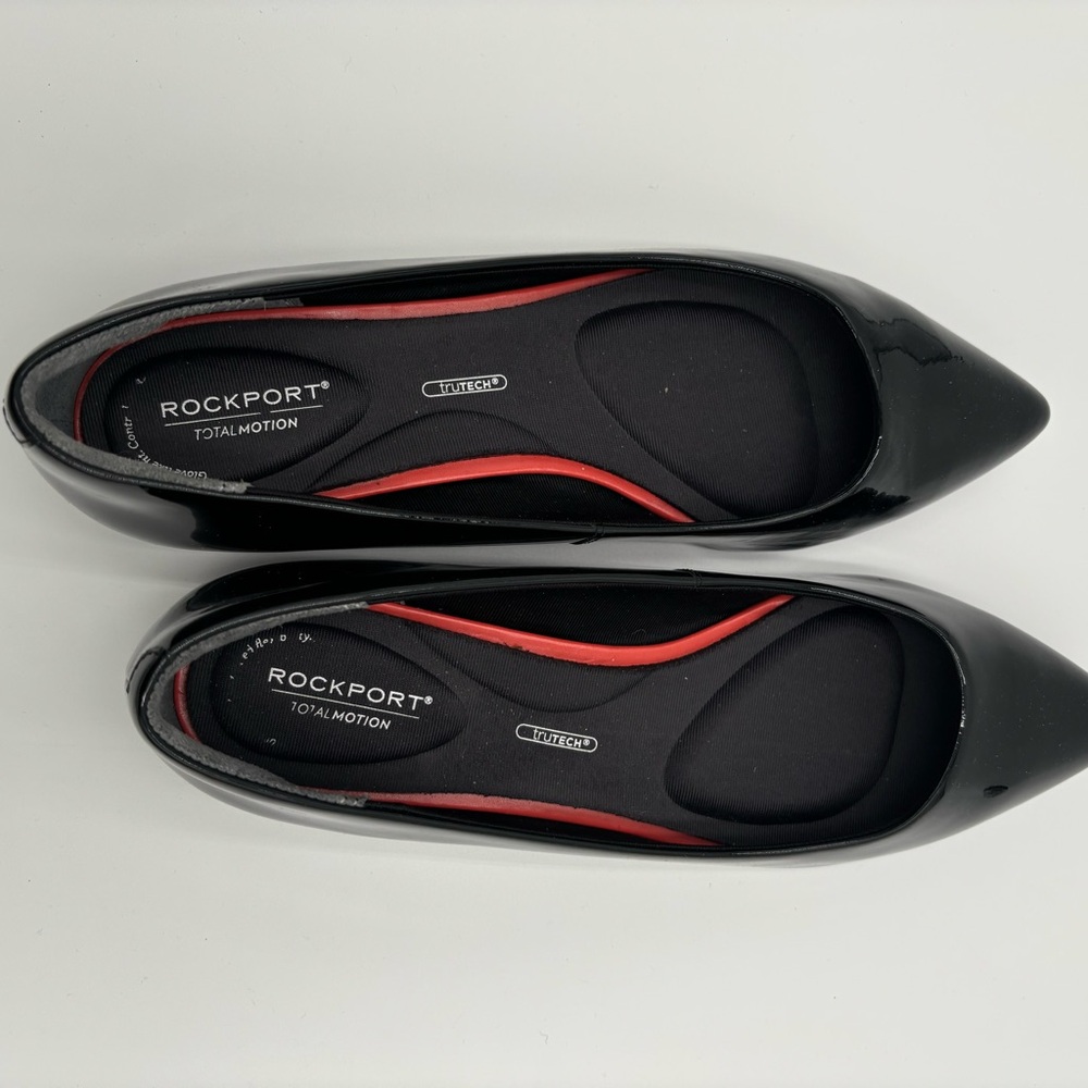 M302 Rockport total motion Women’s flats of black patten. Has cushioned insole.